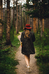 美国科罗拉多州洛基山公园森林中妇女行走的背影图片