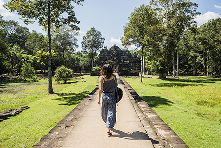 参观柬埔寨暹粒吴哥窟寺庙花园的妇女图片