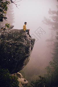 美国加利福尼亚州Shaver湖附近坐在岩石上看着风景的年轻人图片
