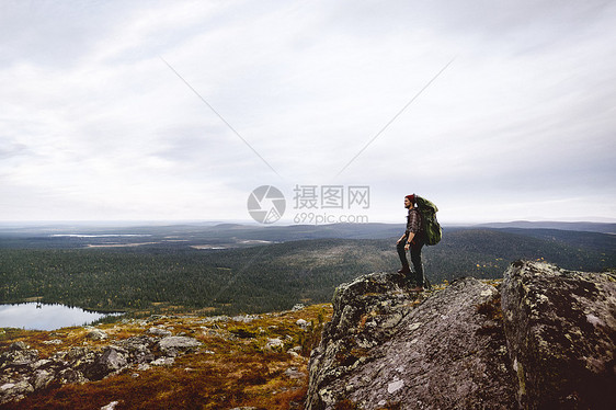 芬兰拉普兰Keimiotunturi徒步旅行者在悬崖顶上欣赏风景图片