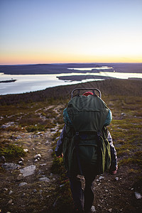 芬兰拉普兰Keimiotunturi湖徒步旅行者在欣赏日落图片