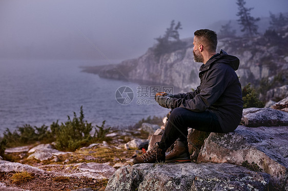 芬兰拉普兰萨基通图里徒步旅行者在悬崖顶上喝咖啡放松图片