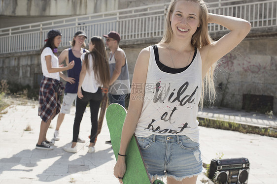 年轻美女手拿滑板图片