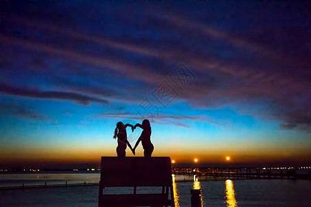 美国新泽西海滨公园日落时用双手塑造儿童爱心形状图片