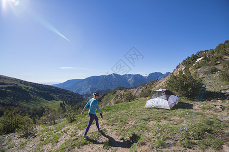 大荒野高山山顶上露营的成年女性图片