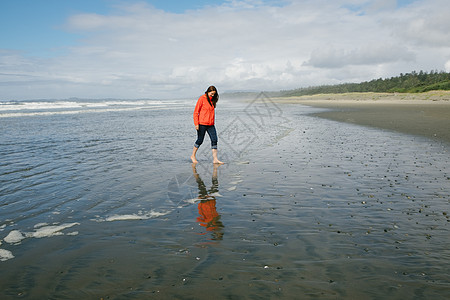 加拿大不列颠哥伦比亚省温华岛长海滩赤脚步行的年轻妇女图片