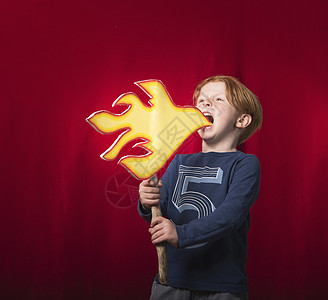 男孩拿着纸板做的火焰假装着喷火背景图片