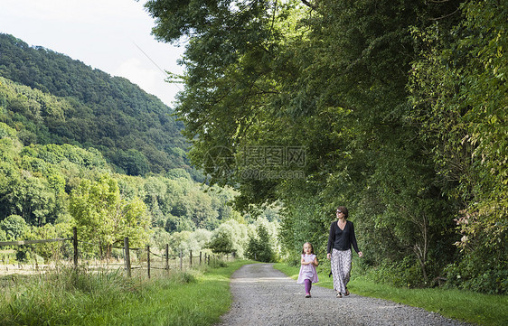 在德国北莱茵威斯特伐利亚州的农村公路上行走的母亲和女儿图片