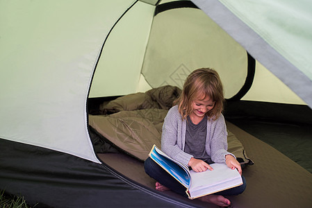 坐在帐篷里看书的女孩图片