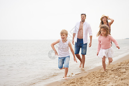 一家四口在沙滩上奔跑图片
