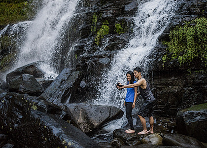 在瀑布前自拍的情侣图片