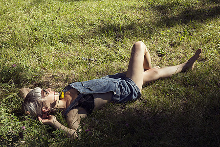 奥地利蒂罗尔Sattelbergalm躺在草地上的中年成妇女图片