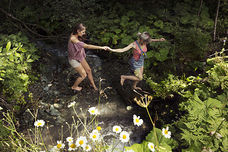 两位女朋友穿越小溪奥地利蒂罗尔萨特尔贝加尔姆图片