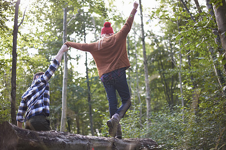 在林中有夫妇手握双臂平衡著落树图片