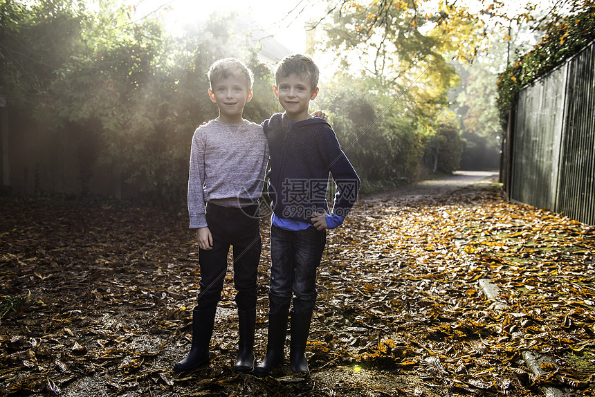 双生男孩的肖像户外秋叶环绕的图片