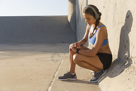 耳机结构配备耳机检查智能观察的女运动员背景