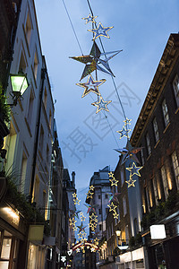 黄昏时城市街道上方的星形圣诞装饰伦敦英国图片