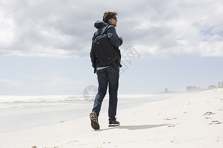 南非西开普海滩上独自漫步的年轻男子近视图片