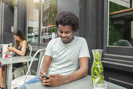 年轻人在城市行咖啡厅看智能手机图片