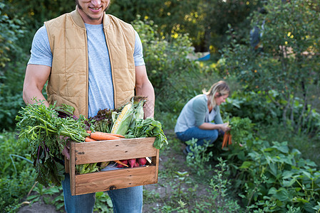 男农民拿着一筐蔬菜图片