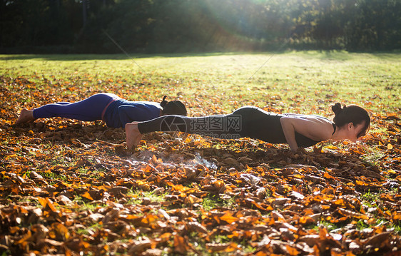 秋天有两个女人在公园做瑜伽图片