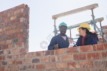 妇女和建筑工人在工地上交谈图片