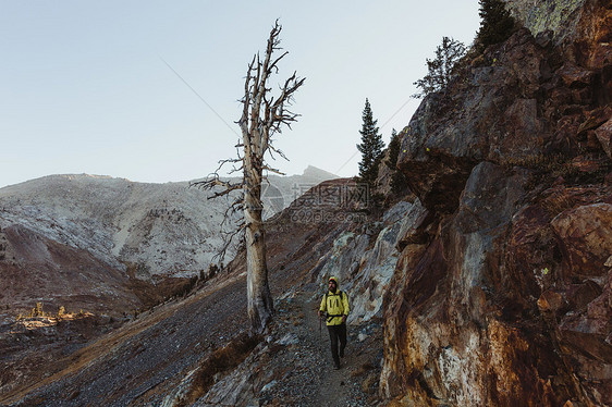美国加利福尼亚州塞科公园矿产金司沿山边徒步旅行的男远足者图片