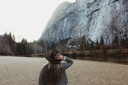 金发背影戴着帽子眺望远方的女性背影背景