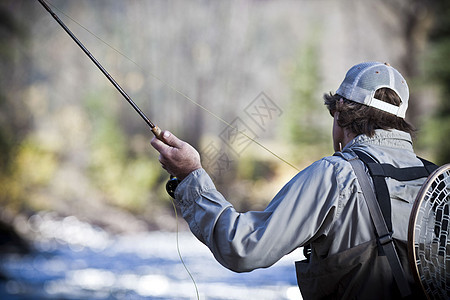 男人握着钓鱼竿背景图片