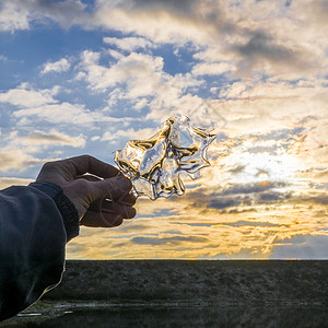 俄罗斯乌拉尔人手握着冰与天空对立图片素材
