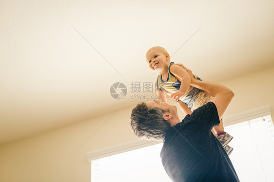 父亲在空气中抱着小儿子低角度视野图片