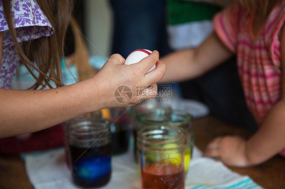 两个年轻姐妹的手准备在桌上制作复活节彩蛋图片