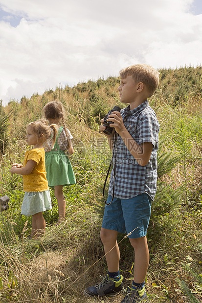 三名幼儿在户外探险男孩拿着望远镜图片