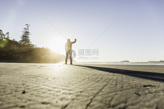 日出时海滩上的男人背影加拿大环太平洋公园图片