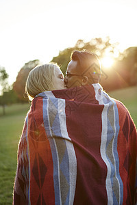一对夫妇在阳光明媚的公园接吻图片