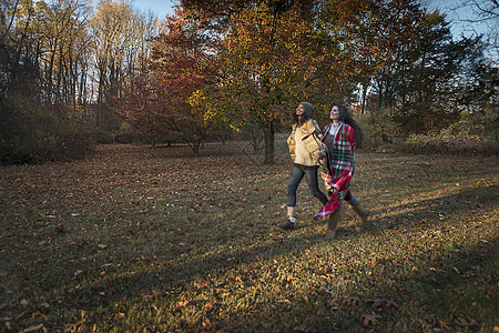 两个女人在秋天的公园里跑步图片