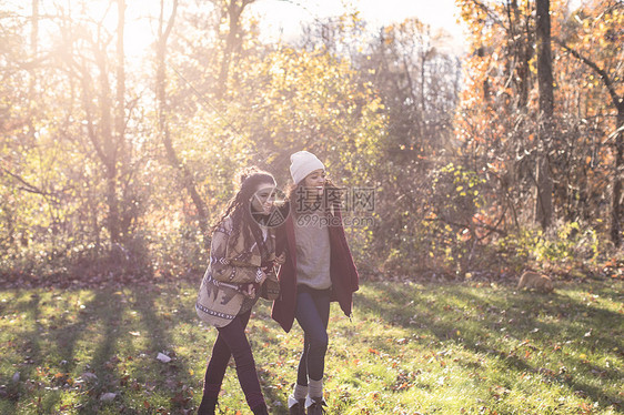 两个年轻女人在秋季的田野散步图片