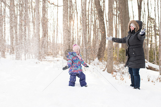 母亲和女儿在雪中玩耍图片