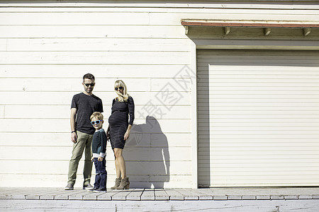 木制建筑旁边的父母和男孩图片