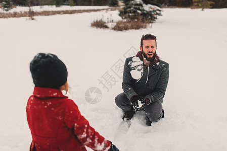 女孩向父亲扔雪球图片