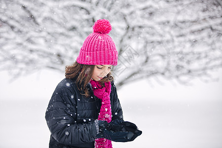 女孩伸出双手接住落下的雪背景图片