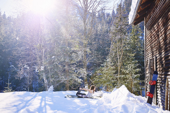 女人在雪地上木屋前做瑜伽奥地利图片