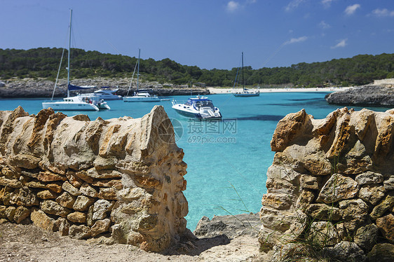 西班牙Majica海湾的传统石墙和海上的游艇图片