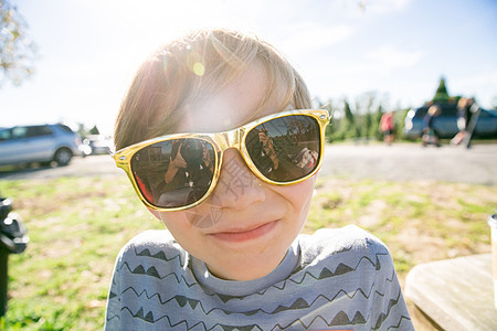 公园里戴墨镜的可爱男孩肖像图片