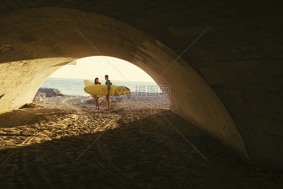 海滩地下通道口的一对情侣图片