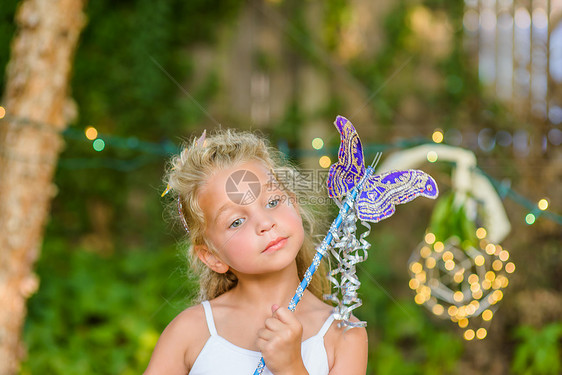 年轻女孩拿着蝴蝶魔杖沉思图片