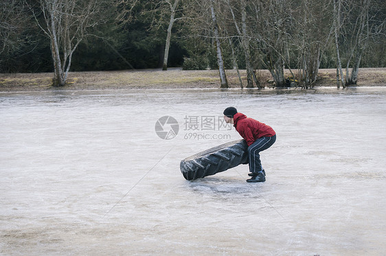 妇女在冷冻湖上翻轮胎图片
