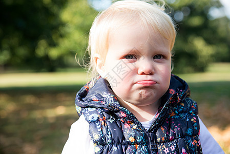 在公园中用嘴唇抽吸的女幼儿肖像图片
