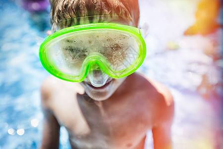 游泳池中男孩戴着充满蒸汽的游泳护目镜图片