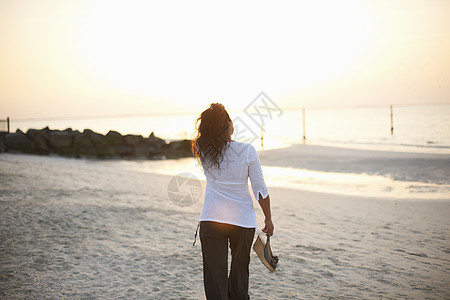 妇女在阿拉伯联合酋长国迪拜海滩上漫步图片